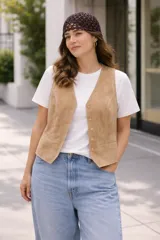 Chaleco sastrero confeccionado en gamuza, con cierre frontal de botones y bolsillos laterales. Presenta un diseño estructurado y elegante, ideal para un look versátil.