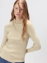 Polera color beige de tejido rib, manga larga y calce ajustado al cuerpo.