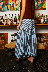 Pantalón babucha de lino con estampado a rayas verticales color celeste y marrón. Presenta corte amplio y tiras para atar en los tobillos.