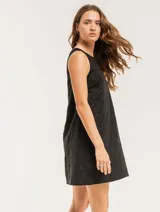 Vestido corto color crema con bordado de lunares negros, sin mangas y con escote redondo.