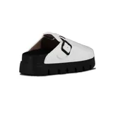 Zueco blanco de mujer con tira ajustable y hebilla negra, sobre plataforma dentada negra.