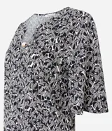 Blusa de viscosa con estampado de follaje en blanco y negro, escote en V y mangas cortas.