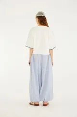 Pantalón aladín de algodón con rayas finas azules y blancas, cintura ajustable con cordón y elástico, bolsillos funcionales y puños elásticos en los tobillos.