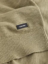 Sweater de cuello redondo Calvin Klein confeccionado en algodón orgánico con textura rugosa. Presenta hombros caídos, puños y bajo acanalados, y una pequeña etiqueta con el logo de la marca en el bajo.