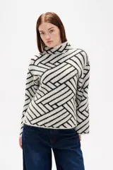 Sweater de tejido jacquard con diseño geométrico de líneas entrelazadas en tonos negro y marrón. Presenta cuello alto, mangas largas con terminación holgada y un corte recto.