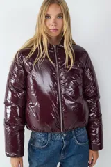 Campera puffer de corte recto con acabado brillante efecto vinilo, cierre frontal completo y cuello clásico.