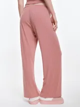Pantalón de dormir de corte recto y holgado, confeccionado en tejido suave con textura acanalada. Presenta cintura elástica con cordón ajustable y bolsillos laterales.