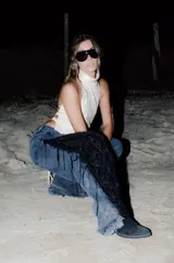 Jeans de corte wide leg en denim negro lavado, con inserción lateral de encaje negro adornado con flecos y lentejuelas.