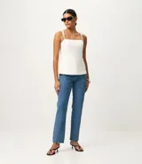 Pantalón de jeans de corte recto, color azul medio, con detalles de strass aplicados en los bolsillos delanteros.