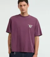 Remera boxy de algodón desteñido color lila, de corte holgado, cuello redondo y manga corta. Cuenta con un pequeño estampado floral en el pecho y un diseño más grande en la espalda.
