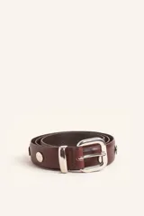 Cinto de cuero color marrón con hebilla metálica plateada y detalles de tachas circulares metálicas a lo largo de la tira.