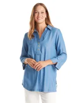 Blusa de lyocell color azul, con cuello camisero, escote en V con cierre de botones y mangas tres cuartos amplias. Presenta un corte holgado con tajos laterales en el ruedo.