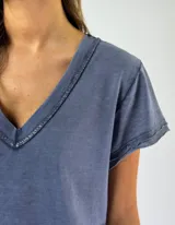 Remera blanca de corte holgado con cuello en V y ribete de crochet.