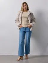 Campera beige capitoneada con capucha, cierre frontal y bolsillos laterales.