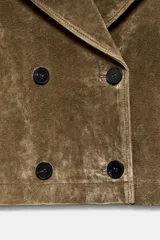 Trench corto de Zara confeccionado en piel de ante, con cuello de solapa, cierre frontal cruzado con botones, mangas largas con trabillas y bolsillos delanteros de vivo.