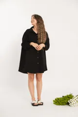 Camisa negra oversize de manga larga con cuello camisero y cierre frontal con botones.