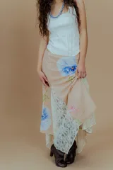 Falda larga color beige con estampado de flores azules y gajos de encaje.