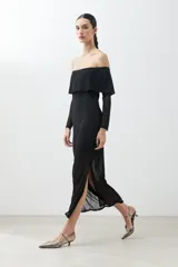 Vestido midi negro con escote bardot, mangas largas de tul y tajo lateral.