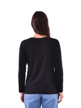 Remera negra de manga larga con cuello redondo y detalle de tachas doradas dispuestas en diagonal sobre el pecho.