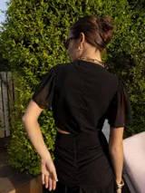 Conjunto de camisa manga larga y falda corta a rayas verticales color beige y blanco. La falda tiene volados y frunces.