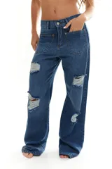 Pantalón de jean azul con corte wide leg y roturas en las rodillas.