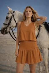 Minifalda de algodón color tostado, con diseño de tiro alto y un amplio volado en el ruedo que aporta movimiento.