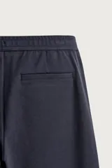 Pantalón negro confeccionado en mezcla de algodón, con cintura elástica, bolsillos frontales y cierre con cremallera y botón.