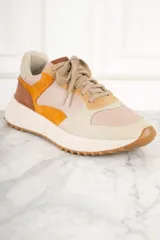 Zapatillas urbanas de cuero color beige, con detalles en amarillo, naranja y marrón.