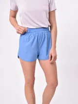 Short deportivo color azul celeste, con cintura elástica fruncida y corte holgado.