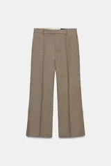 Pantalón de corte cropped flare confeccionado en tejido con lana. Presenta tiro medio, cintura con trabillas, bolsillos laterales ocultos y detalle de nervio frontal. Cierre con cremallera, botón y ganchos metálicos.
