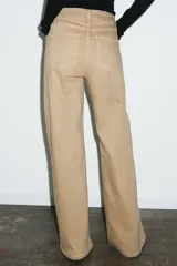 Jeans de tiro alto con corte wide leg y largo completo. Presenta diseño de cinco bolsillos, cintura con trabillas y cierre frontal con cremallera y botón.