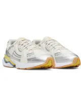 Championes UA Sola de diseño retro con capellada de malla blanca, superposiciones en tonos off-white, detalles plateados, y acentos en celeste y amarillo en la entresuela. Suela de goma color suela.