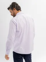 Camisa de manga larga marca Cuatro Ases, confeccionada en algodón con diseño de microcuadros en tono azul claro. Presenta cuello clásico con botones, cierre frontal abotonado y bolsillo en el pecho.