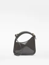 Bolso de cóctel Adolfo Domínguez de estructura rígida y acabado brillante. Presenta un diseño asimétrico con asa tubular integrada y correa larga extraíble. Cuenta con cierre magnético y logo de la marca estampado en dorado.