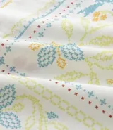 Camisa blanca de lino y algodón, de corte comfort, cuello inglés y abotonado frontal. Presenta manga corta y un bordado floral multicolor con motivos de aves y flores.