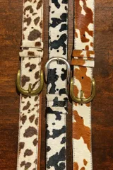 Cinto de cuero vacuno con pelo natural, con diseño de manchas tipo animal print. Cuenta con hebilla metálica y costuras reforzadas.