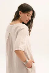 Vestido corto color arena de lino, con cuello en V y mangas cortas.