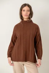 Buzo de punto color chocolate con cuello alto, mangas largas y diseño de trenzas verticales. Presenta puños y ruedo acanalados.