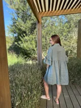 Vestido camisero blanco de lino italiano, con cuello camisero, cierre frontal con botones, mangas cortas con doble volado y bolsillos laterales.