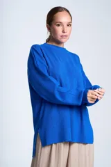 Sweater azul eléctrico de punto acanalado, con cuello redondo y mangas largas. Corte holgado con aberturas laterales.