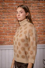 Sweater de punto con cuello alto y mangas tres cuartos, con diseño estampado de lunares en tonos beige y marrón.