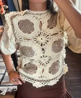 Chaleco de crochet tejido a mano, color crema y marrón topo, con diseño de flores estilo granny squares y cuello redondo con volado.
