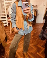 Chaleco de cuero vacuno color marrón claro con flecos largos en el frente.