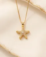 Collar de bronce con cadena fina dorada y dije en forma de estrella de mar pavimentado con circonias.