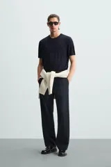 Camiseta negra de punto con cuello redondo, manga corta y corte regular. Tejido de viscosa con acabado en rib.