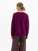 Sweater de punto con textura suave, de silueta relajada y largo por debajo de la cadera. Presenta cuello redondo, mangas largas y costuras laterales desplazadas hacia el frente.