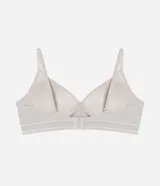 Soutien tipo bralette de color blanco hueso, sin costuras (seamless), con copas moldeadas y escote en V. Presenta una banda ancha elástica bajo el busto para mayor soporte y tirantes finos ajustables.