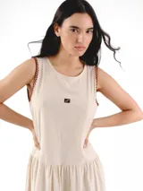 Vestido largo sin mangas, de corte amplio y relajado, con estampa a cuadros, escote redondo y falda fruncida. Cuenta con detalles de costura a contratono en las sisas y logo frontal.
