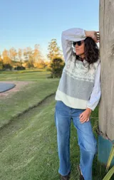 Chaleco tejido en mohair con diseño de guarda geométrica en la parte superior. Presenta una combinación de colores gris, blanco y beige, con cuello redondo y corte recto.