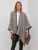 Ruana color beige de tejido suave, con vivos en ecocuero negro.